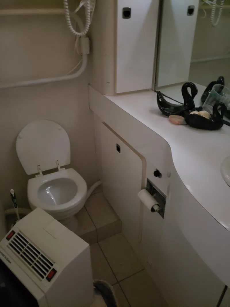Slide: The Image of 1993 Silverton 41 Aft Cabin bathroom with toilet, vanity, and heater. - 2