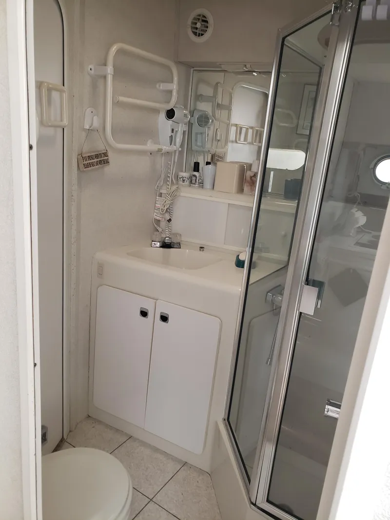 Slide: The Image of 1993 Silverton 41 Aft Cabin bathroom with shower, sink, and storage cabinets. - 5