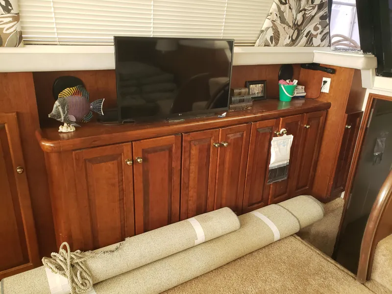 Slide: The Image of 1993 Silverton 41 Aft Cabin interior with TV, wooden cabinets, and rolled carpet. - 8