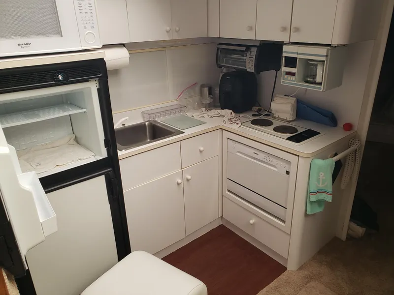 Slide: The Image of Compact kitchen in a 1993 Silverton 41 Aft Cabin yacht with appliances and storage. - 9