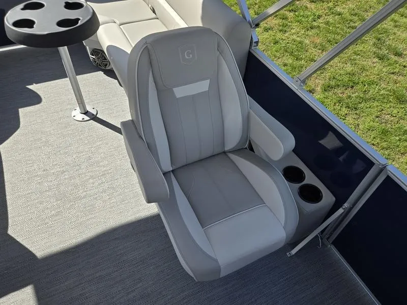 Slide: The Image of Captain's chair on 2025 Godfrey Xperience 2286 SBX Sport Tube boat, featuring cup holders and table. - 10
