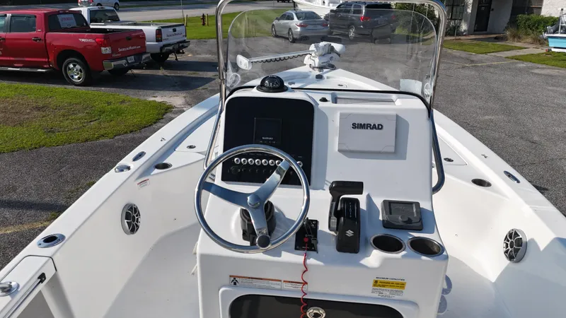 Slide: The Image of 2021 Sea Pro 228 boat dashboard with steering wheel and Simrad navigation system. - 8