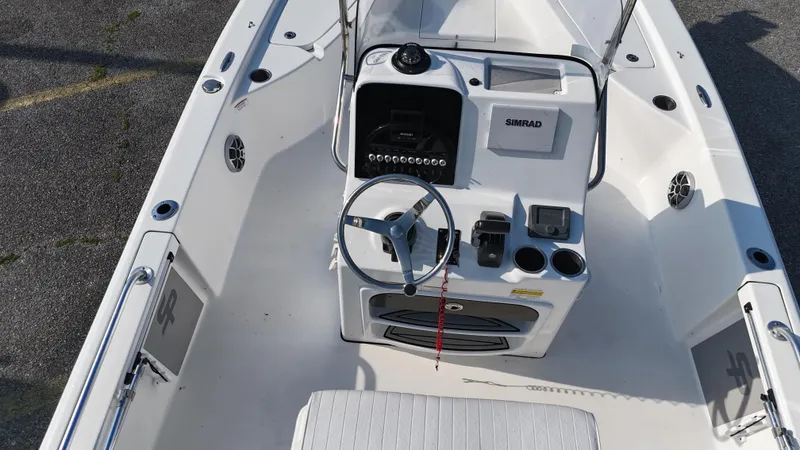 Slide: The Image of 2021 Sea Pro 228 boat interior with steering wheel, control panel, and seating. - 9