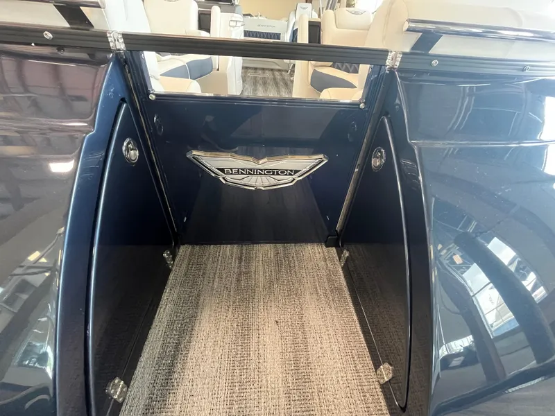 Slide: The Image of 2025 Bennington 25QXSBA boat interior with carpeted flooring and seating. - 11