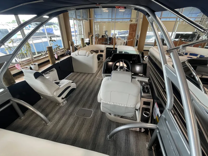 Slide: The Image of Interior of 2025 Bennington 25QXSBA boat with modern seating and steering console. - 16