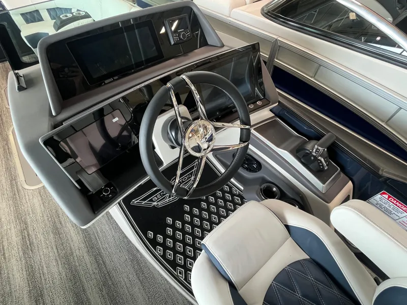 Slide: The Image of Interior view of 2025 Bennington 25QXSBA boat cockpit with steering wheel and controls. - 19