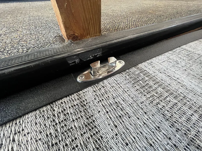 Slide: The Image of Close-up of a 2025 Bennington 25QXSBA boat latch on textured flooring. - 26