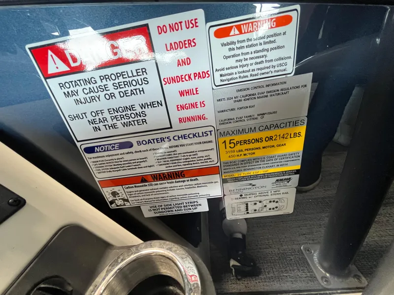 Slide: The Image of Warning labels and capacity information on a 2025 Bennington 25QXSBA boat. - 27