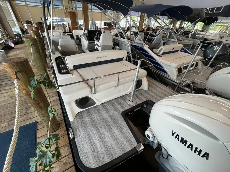 Slide: The Image of 2025 Bennington 25QXSBA pontoon boat with Yamaha engine, docked indoors. - 3