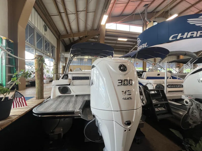 Slide: The Image of 2025 Bennington 25QXSBA boat with powerful 300 V8 engine displayed indoors. - 4