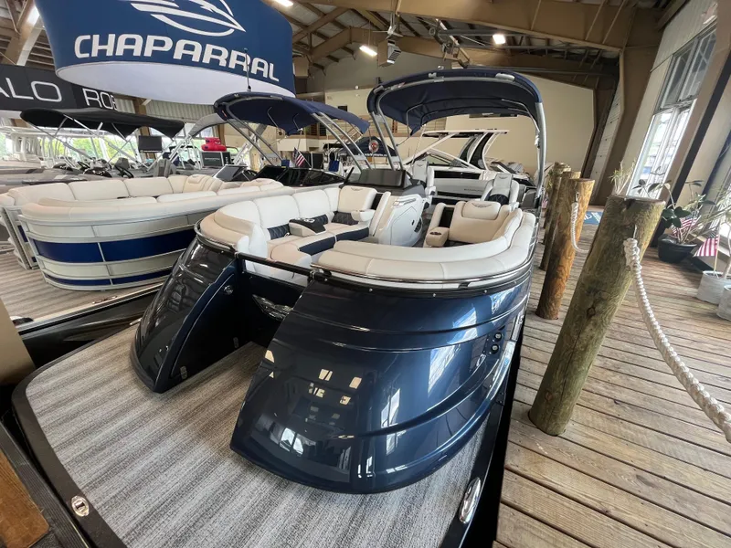 Slide: The Image of 2025 Bennington 25QXSBA pontoon boat displayed indoors with luxury seating. - 5