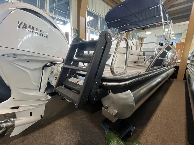 Slide: The Image of 2025 Bennington 25QXSBA pontoon boat with Yamaha engine, displayed indoors. - 6