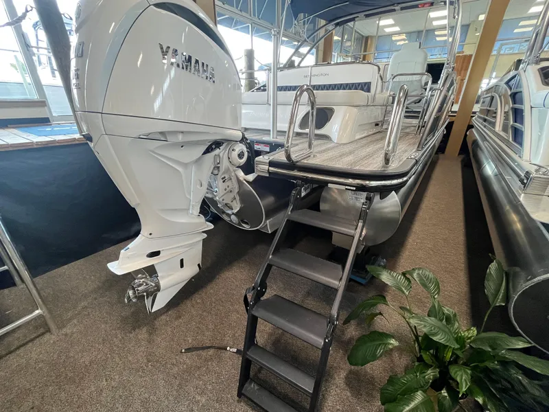 Slide: The Image of 2025 Bennington 25QXSBA boat with Yamaha engine and boarding ladder in showroom. - 7