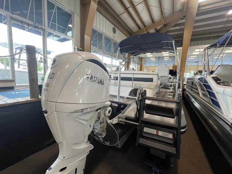 Slide: The Image of 2025 Bennington 25QXSBA pontoon boat with Yamaha outboard motor in showroom. - 9