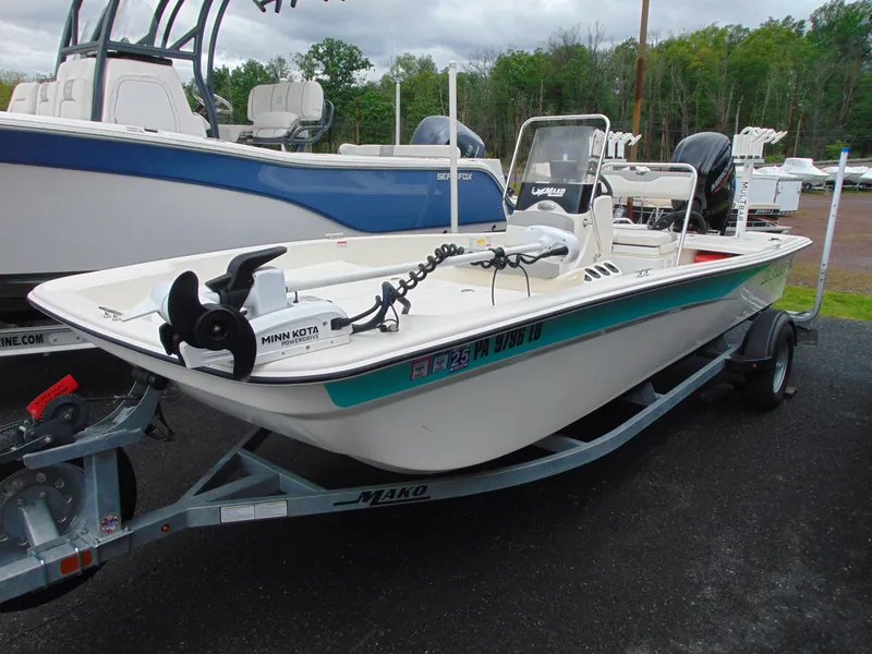 Slide: The Image of 2023 Mako Pro Skiff 17 CC boat on trailer, equipped with Minn Kota trolling motor. - 1