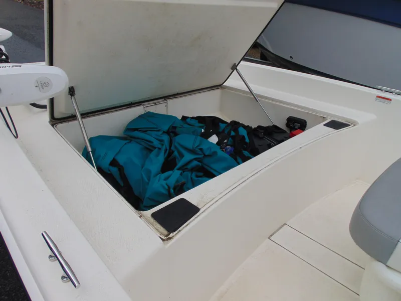 Slide: The Image of Open storage compartment on 2023 Mako Pro Skiff 17 CC boat with gear inside. - 12