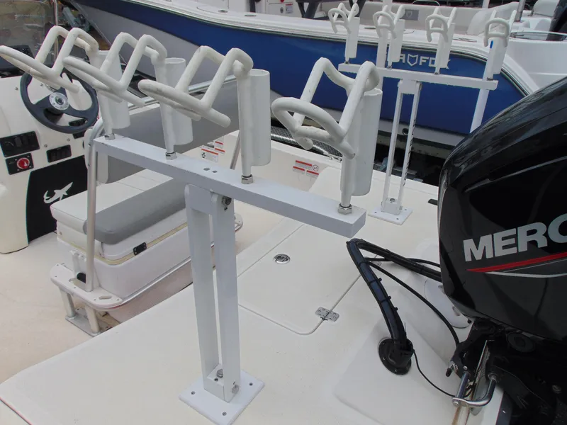 Slide: The Image of 2023 Mako Pro Skiff 17 CC with rod holders and Mercury outboard motor. - 8
