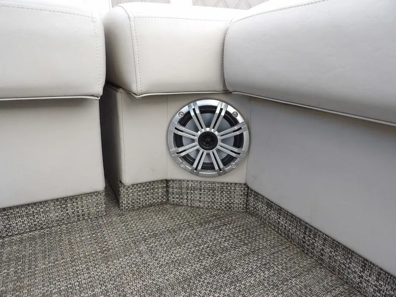 Slide: The Image of 2016 Bennington 2874 QSR boat interior with speaker and beige upholstery. - 21