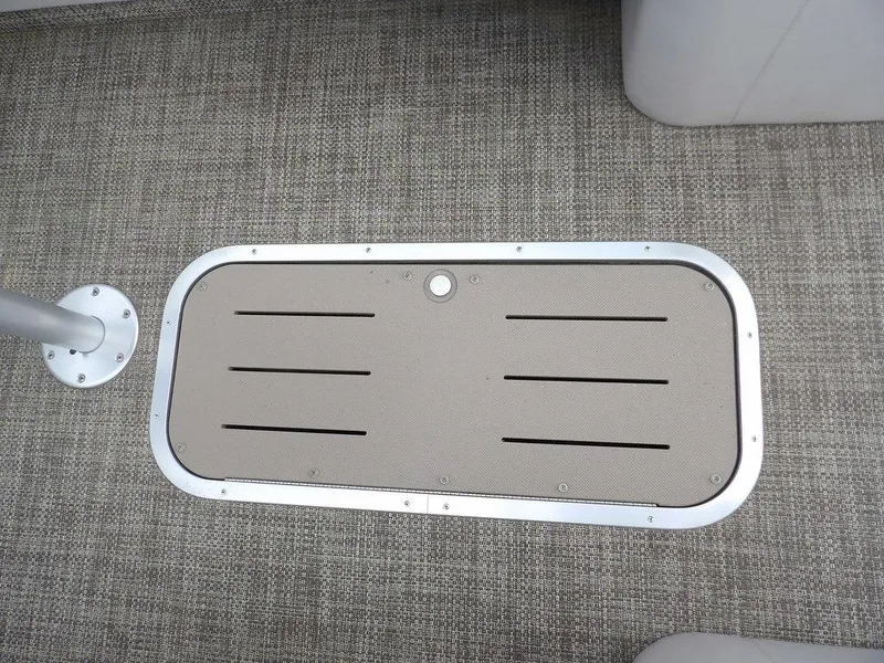 Slide: The Image of 2016 Bennington 2874 QSR boat floor with textured carpet and metal hatch cover. - 23
