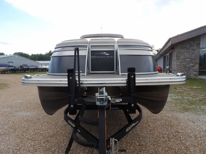 Slide: The Image of 2016 Bennington 2874 QSR pontoon boat on a trailer, parked outdoors. - 3