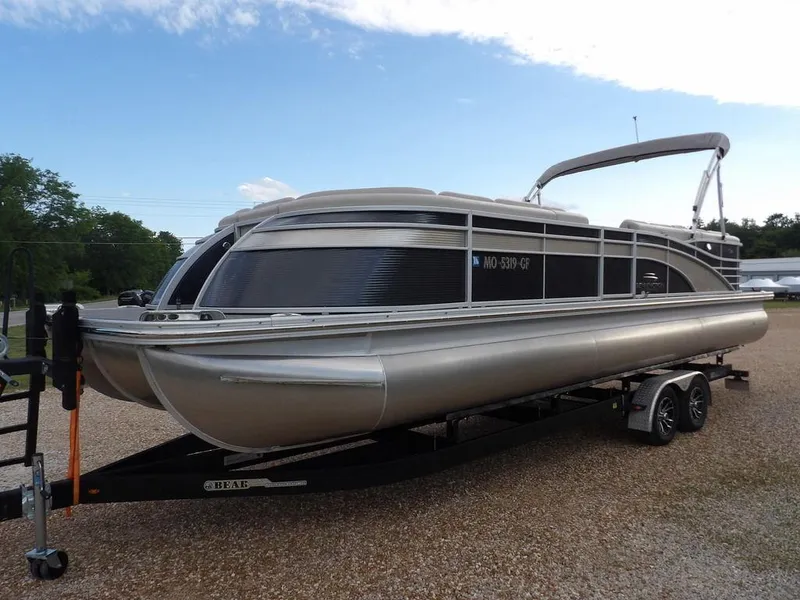 Slide: The Image of 2016 Bennington 2874 QSR pontoon boat on a trailer, parked on gravel. - 4