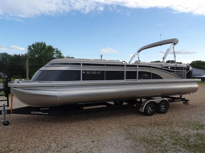 Slide: The Image of 2016 Bennington 2874 QSR pontoon boat on a trailer, parked outdoors. - 5