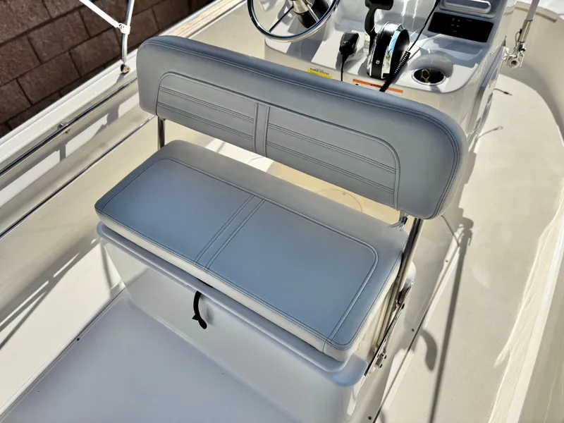 Slide: The Image of 2021 Boston Whaler 170 Montauk boat interior with cushioned seating and steering console. - 20
