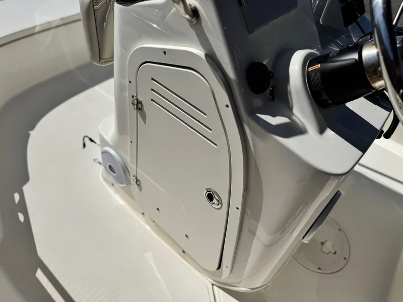 Slide: The Image of 2021 Boston Whaler 170 Montauk console detail with steering wheel and storage compartment. - 22