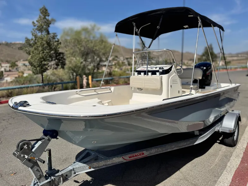 Slide: The Image of 2021 Boston Whaler 170 Montauk boat on trailer, parked outdoors with bimini top. - 3
