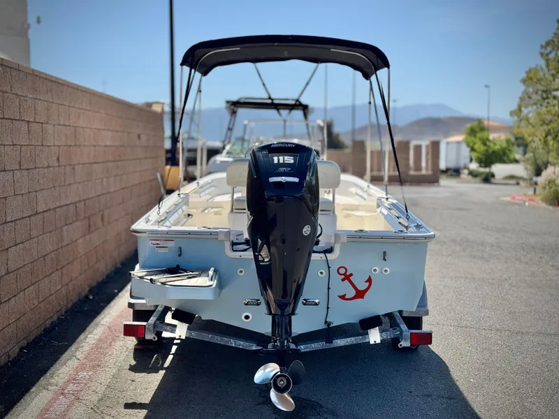 Slide: The Image of 2021 Boston Whaler 170 Montauk boat with outboard motor and canopy, parked on a trailer. - 4