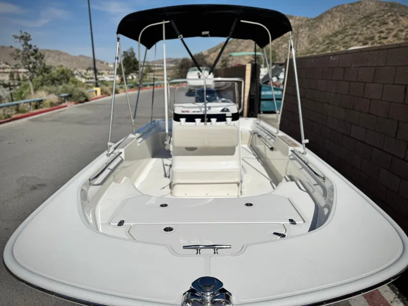 Slide: The Image of 2021 Boston Whaler 170 Montauk boat with canopy, parked on a sunny street. - 8