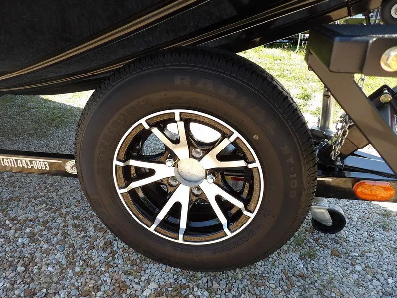 Slide: The Image of Close-up of a 2020 G3 Sportsman 1810 trailer wheel on gravel. - 49
