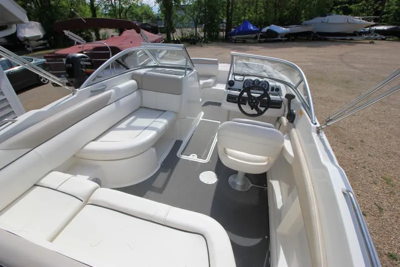Slide: The Image of 2013 Bayliner 190 Deck Boat interior with white seating and steering wheel. - 10
