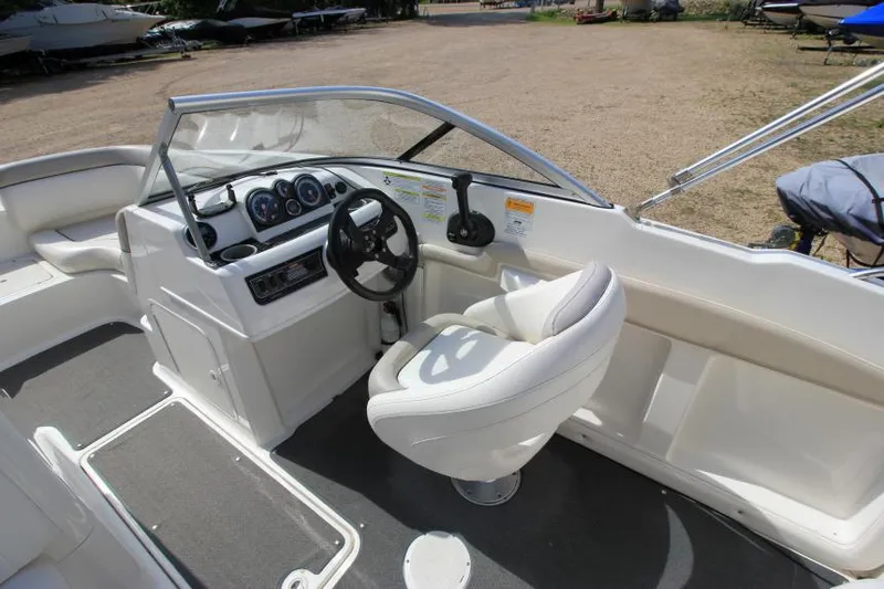 Slide: The Image of 2013 Bayliner 190 Deck Boat interior with steering wheel and seating. - 14