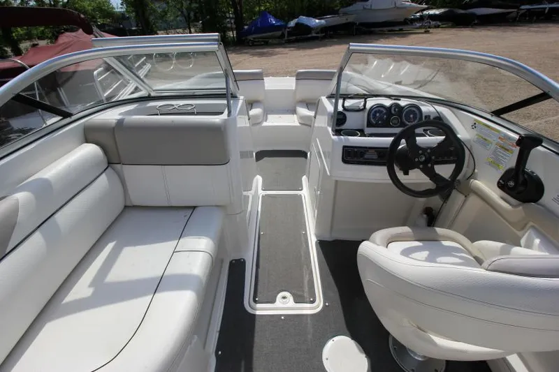 Slide: The Image of 2013 Bayliner 190 Deck Boat interior with white seating and steering console. - 17
