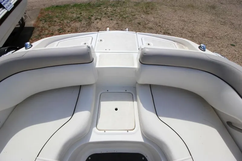 Slide: The Image of 2013 Bayliner 190 Deck Boat interior with white seating and storage compartments. - 22