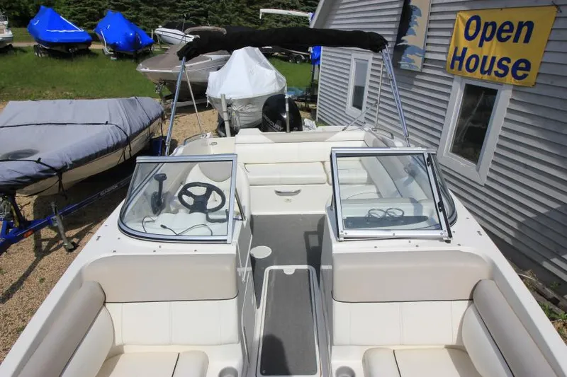 Slide: The Image of 2013 Bayliner 190 Deck Boat at open house event, featuring spacious seating and dual consoles. - 25