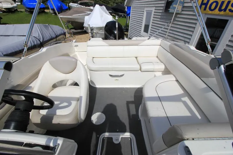Slide: The Image of 2013 Bayliner 190 Deck Boat interior with white seating and steering wheel. - 26
