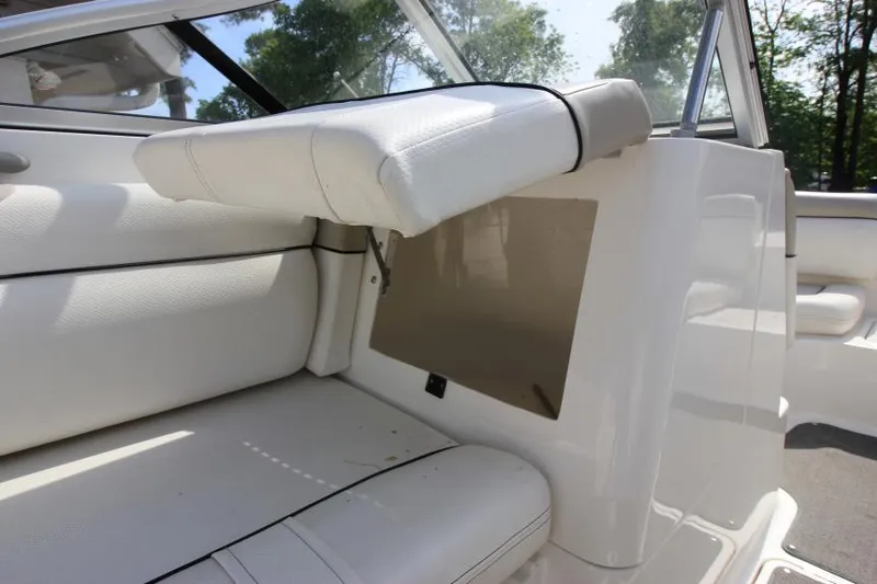 Slide: The Image of 2013 Bayliner 190 Deck Boat interior with white seating and storage compartment. - 27