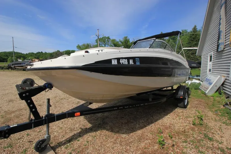 Slide: The Image of 2013 Bayliner 190 Deck Boat on trailer, parked outdoors under clear sky. - 5