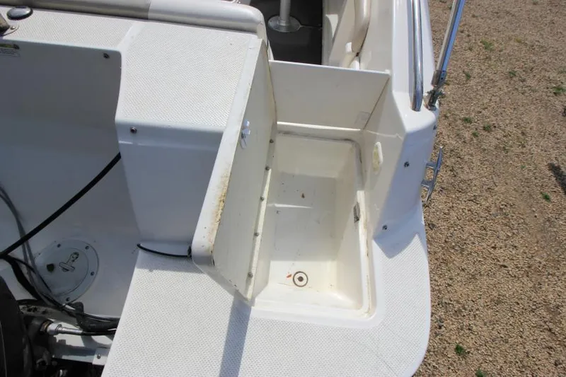 Slide: The Image of 2013 Bayliner 190 Deck Boat storage compartment with open hatch, showing interior details. - 9