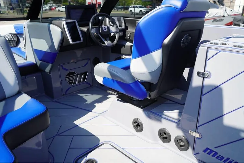 Slide: The Image of 2022 Malibu Wakesetter 25 LSV interior with blue and gray seating, modern dashboard. - 9