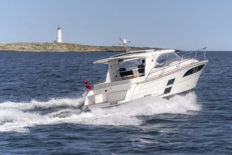 Slide: The Image of 2025 Marex 310 Sun Cruiser navigating near a lighthouse on open water. - 15