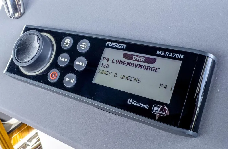 Slide: The Image of Digital radio display on 2025 Marex 310 Sun Cruiser, showing station and song details. - 26