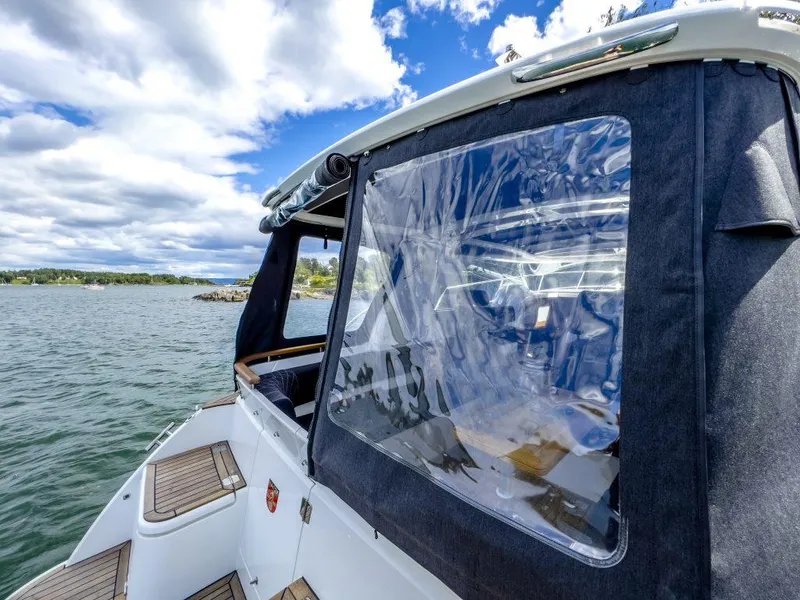 Slide: The Image of 2025 Marex 310 Sun Cruiser on water, featuring clear canopy and wooden deck accents. - 30