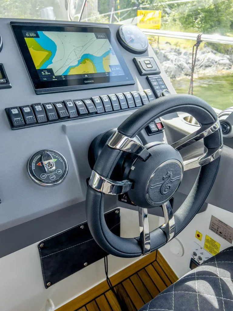 Slide: The Image of 2025 Marex 310 Sun Cruiser dashboard with navigation display and steering wheel. - 34