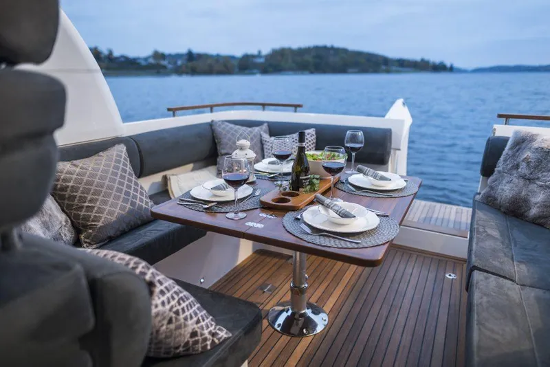 Slide: The Image of Luxurious dining setup on 2025 Marex 310 Sun Cruiser yacht, overlooking serene waters. - 38