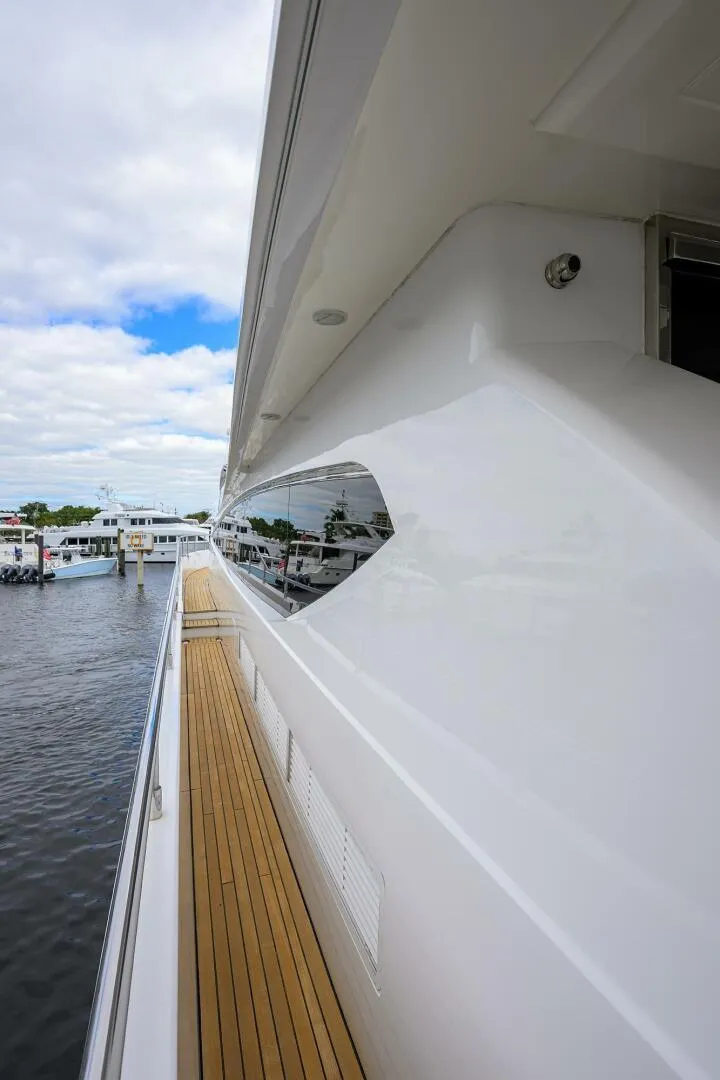 Slide: The Image of Side view of a 2009 Princess 95 yacht with sleek design and wooden deck. - 10