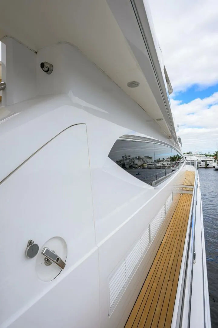 Slide: The Image of Side view of a 2009 Princess 95 yacht with sleek design and wooden deck. - 11