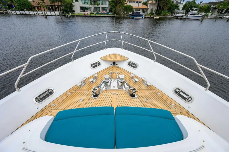Slide: The Image of Bow view of 2009 Princess 95 yacht with teak deck and blue cushions. - 13
